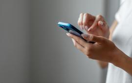 Image of person holding a blue cell phone and making a call