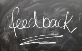 The word "Feedback" written on a chalkboard with white chalk