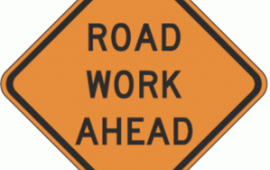 Road work ahead orange sign with black text