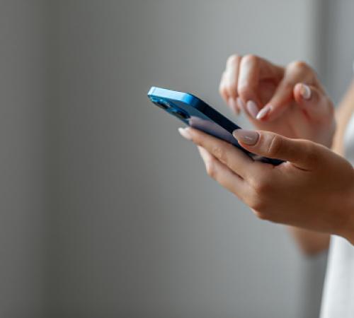 Image of person holding a blue cell phone and making a call