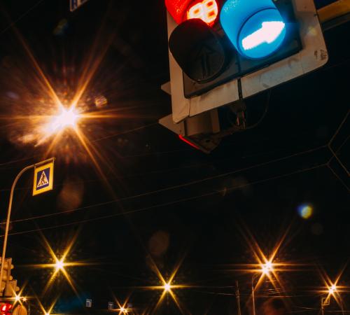 Traffic signal with streetlights in the background at nighttime