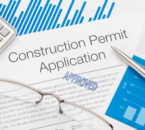 Image of Construction Permit Application, a pen, glasses and calculator