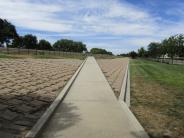 Sidewalk and brick walkway through the large dog area at Lathrop Dog Park at River Park South