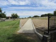 Sidewalk and brick walkway through small dog area at Lathrop Dog Park at River Park South