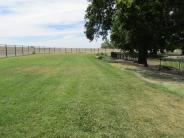 Green grass area inside small dog area at Lathrop Dog Park at River Park South