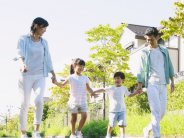 Two adults and two children walk through a neighborhood
