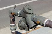 Backflow device on sidewalk near intersection/street