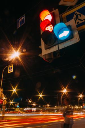 Traffic signal with streetlights in the background at nighttime