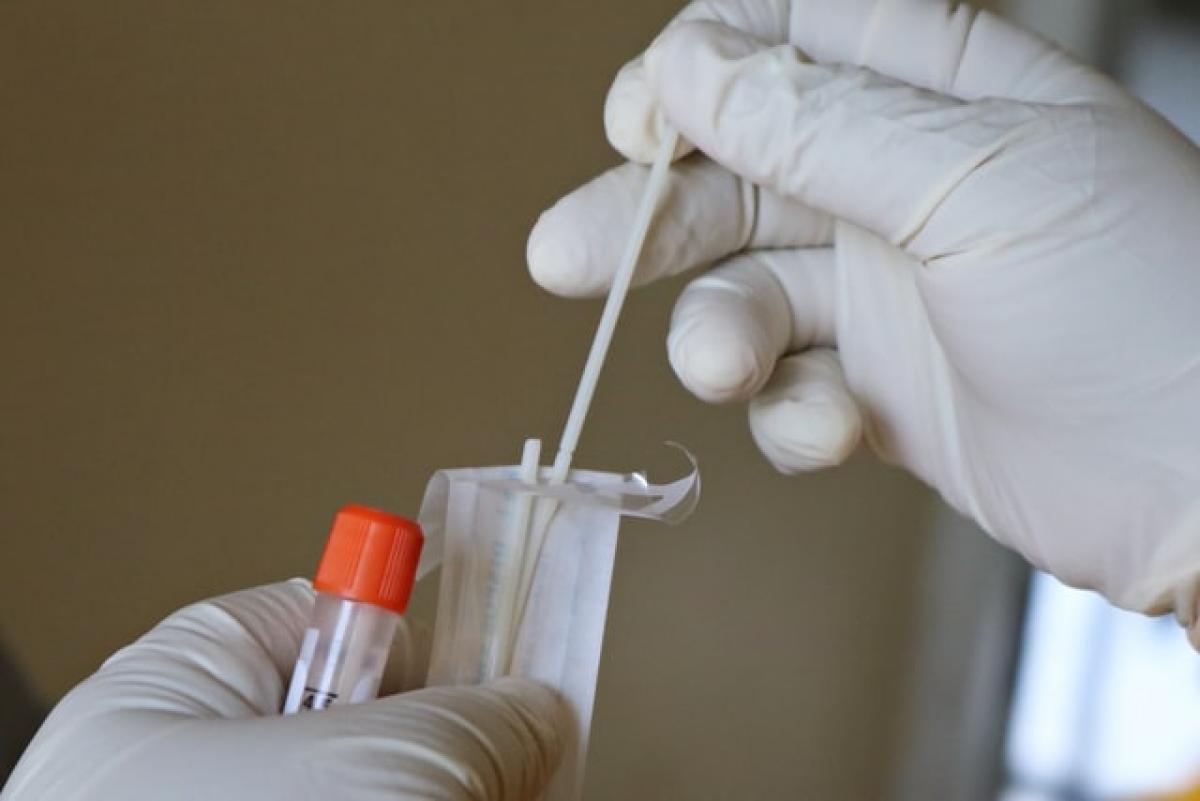 Picture of Laboratory Technician's hands holding a test tube and swap