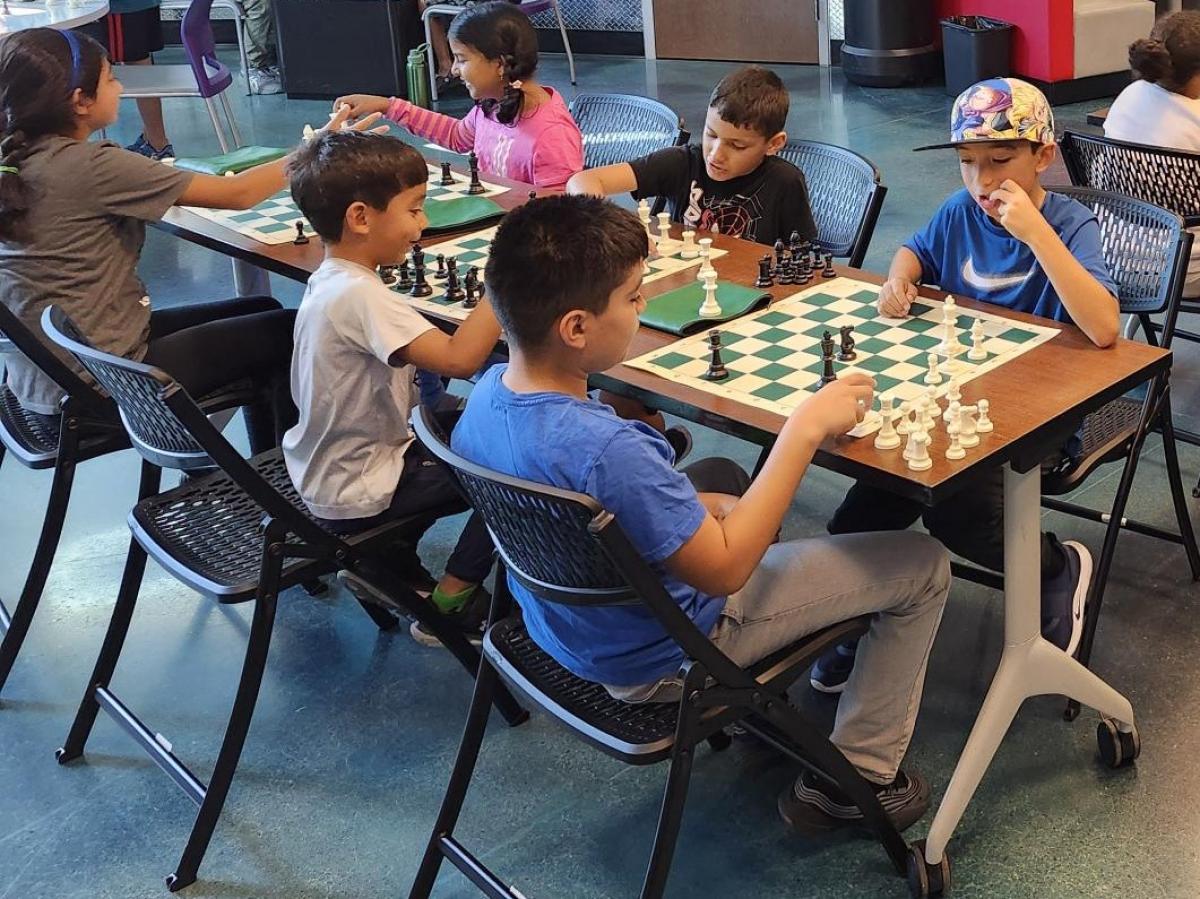 Kids play chess at chess camp 