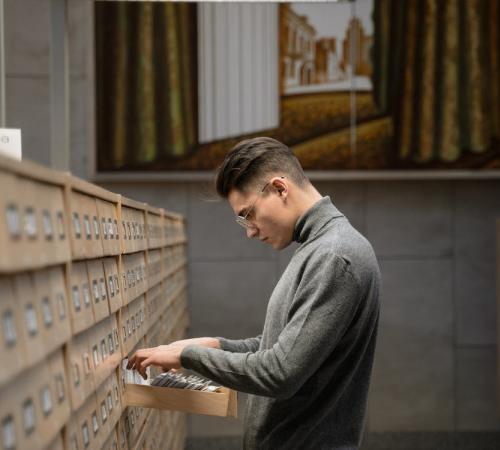 MAN LOOKING THROUGH ARCHIVES